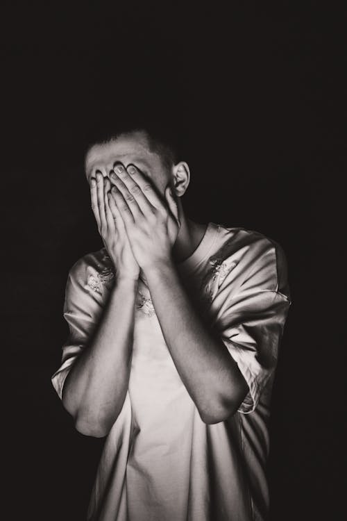 Free Grayscale Photo of a Man Covering His Face Stock Photo