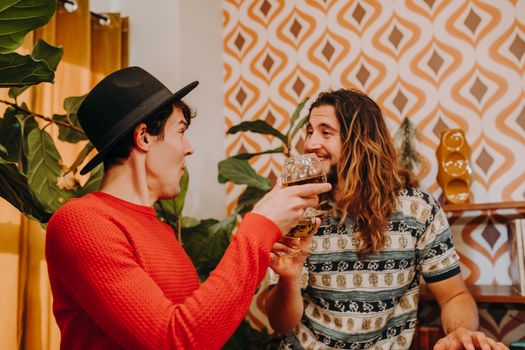 Two friends enjoying a lively conversation with drinks in a stylish vintage setting.