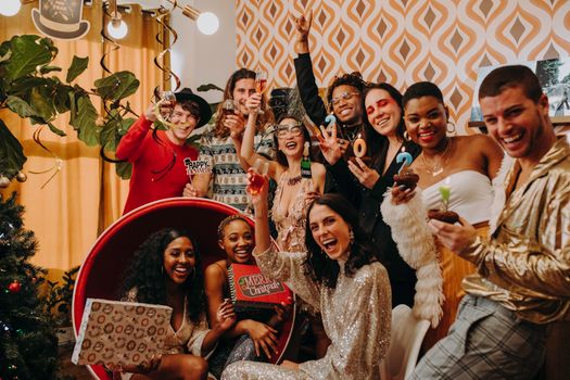 A lively party scene with a diverse group celebrating New Year's Eve indoors with drinks and decorations.
