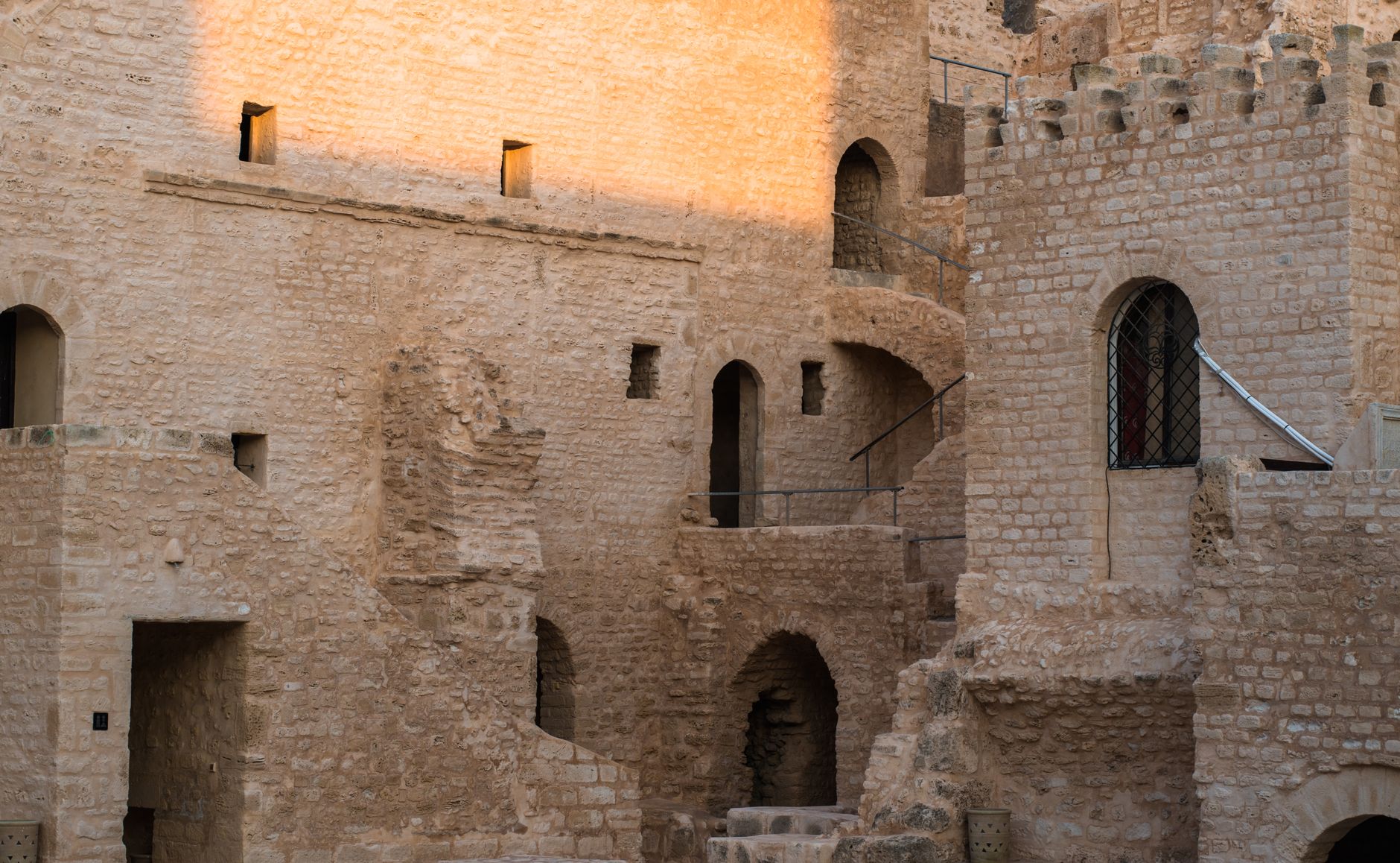 A detailed view of ancient stone castle architecture with gothic arches and intricate brickwork. — free online jigsaw puzzle on JigsawPuzzlesFreeOnline.org