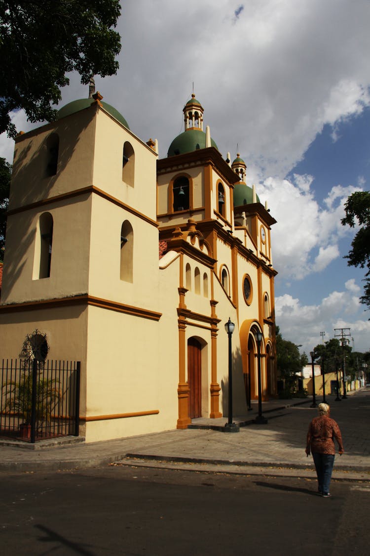 Woman Walking On An Empty Street By A Church 