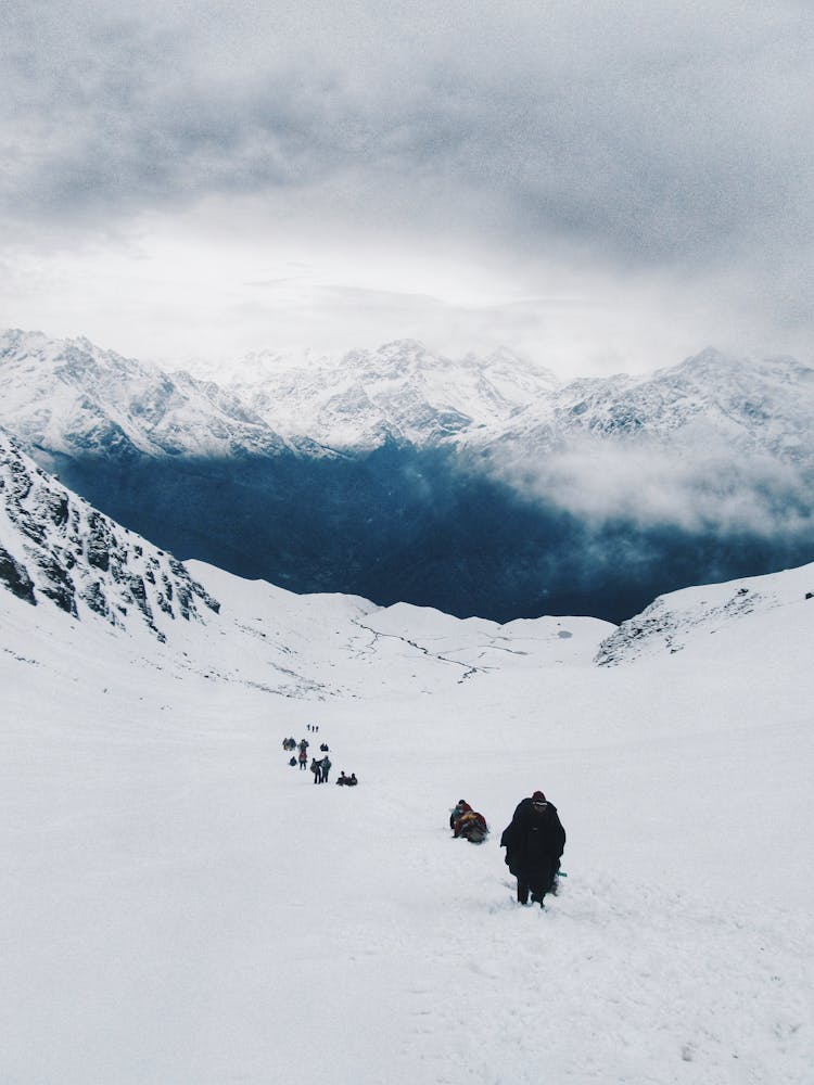 Man Leading Group Through Snowy Mountains