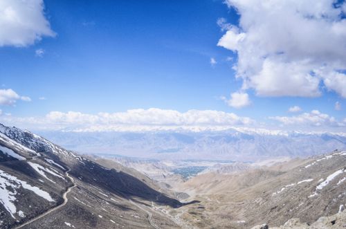 Free A breathtaking aerial view of snow-capped mountains and valleys under a clear blue sky. Stock Photo