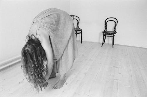Monochrome Photo of a Woman Bowing Down