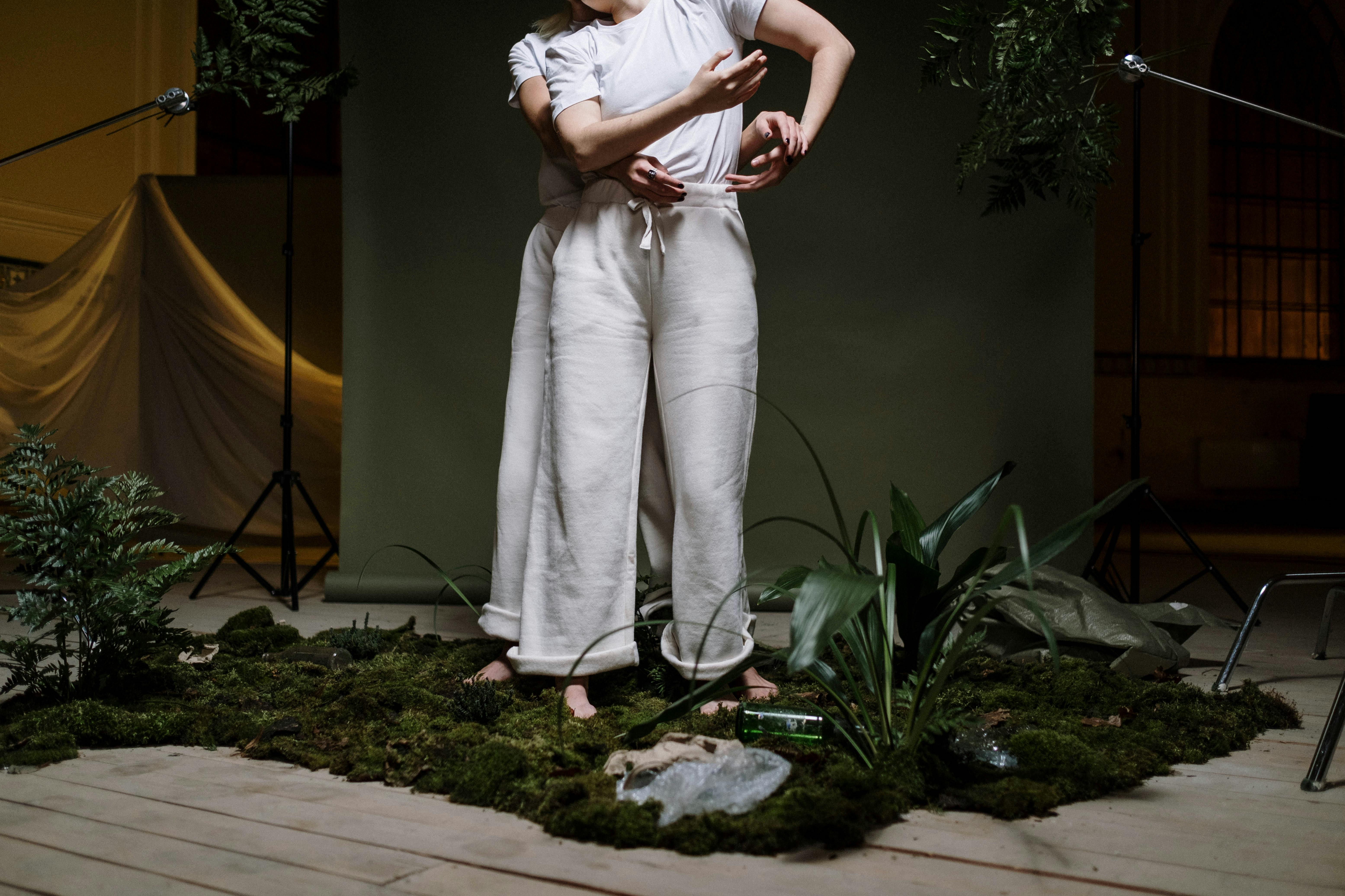 woman in white dress standing near green plant