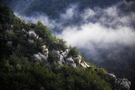 Breathtaking view of misty mountains in Sulmona, Abruzzo with lush greenery and rocky formations.
