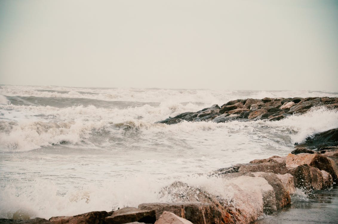 Beige Image of a Sea Coast with Rocks at Storm