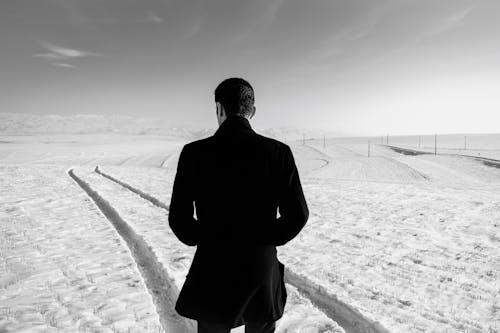모래에 서있는 검은 양복에 남자