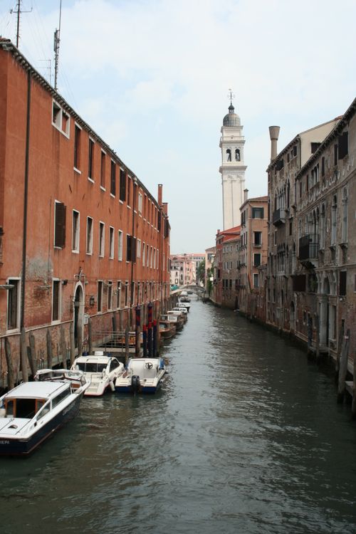 Free Capture of a serene Venetian canal with gondolas, historic architecture, and a towering campanile. Stock Photo