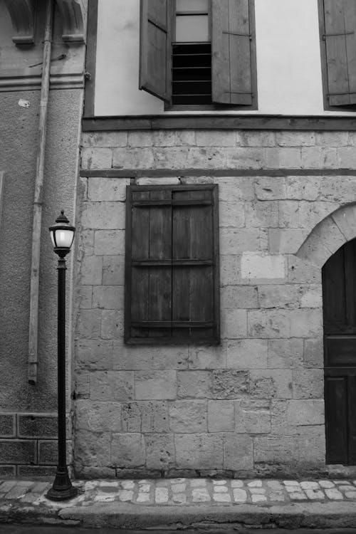 Free Black and White Photo of an Old Town Street with Lamp and Window Shutters Stock Photo