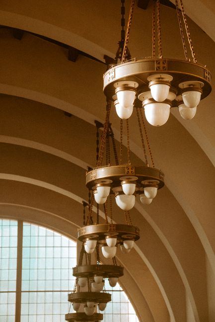 Beautiful vintage chandeliers hanging in a historic San Diego building, showcasing elegant architectural design.