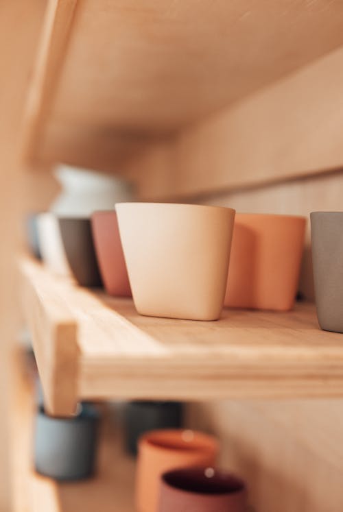 Set of various ceramic pots on shelves in workshop