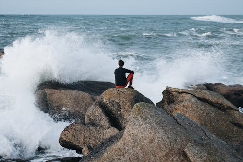 Man Contemplating Seascape Sitting on Stones