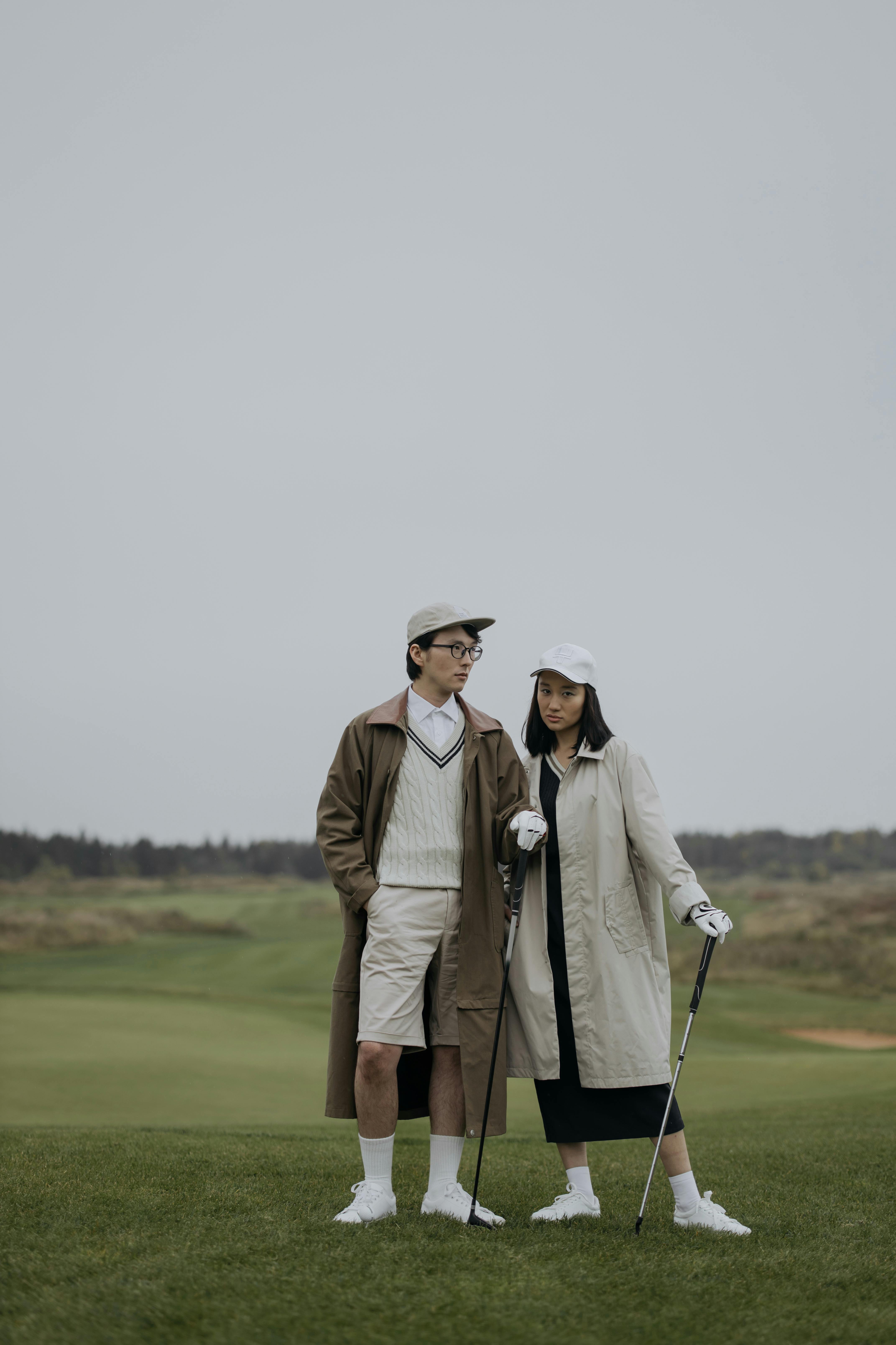 man in brown coat holding golf club