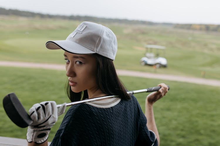 Woman In White Cap With Golf Club