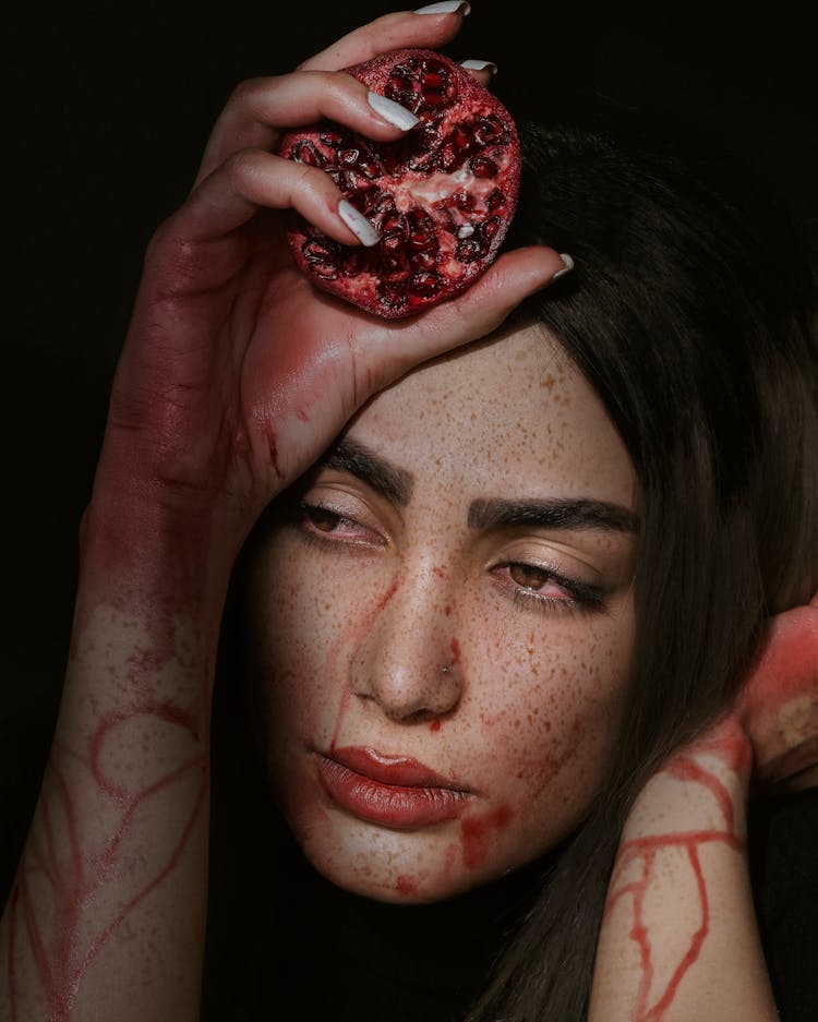 Woman With Pomegranate Juice On Hands And Face