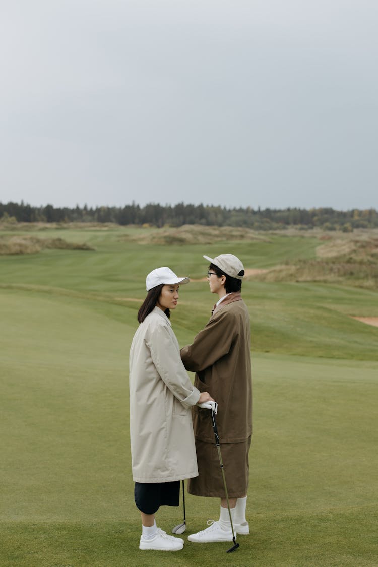 Stylish Couple Standing On Grass Field