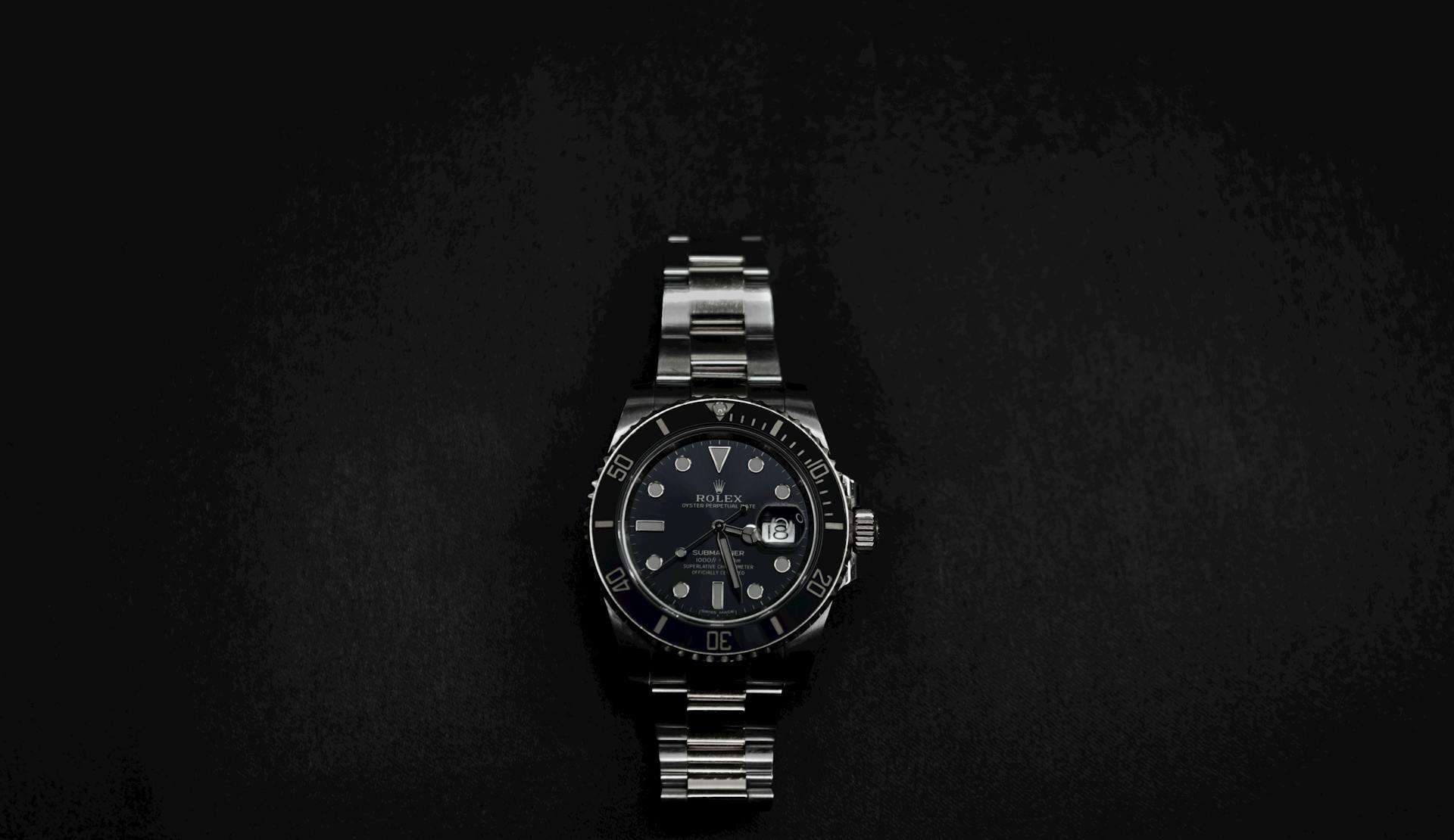 Close-up of an elegant Rolex wristwatch on a sleek black background.