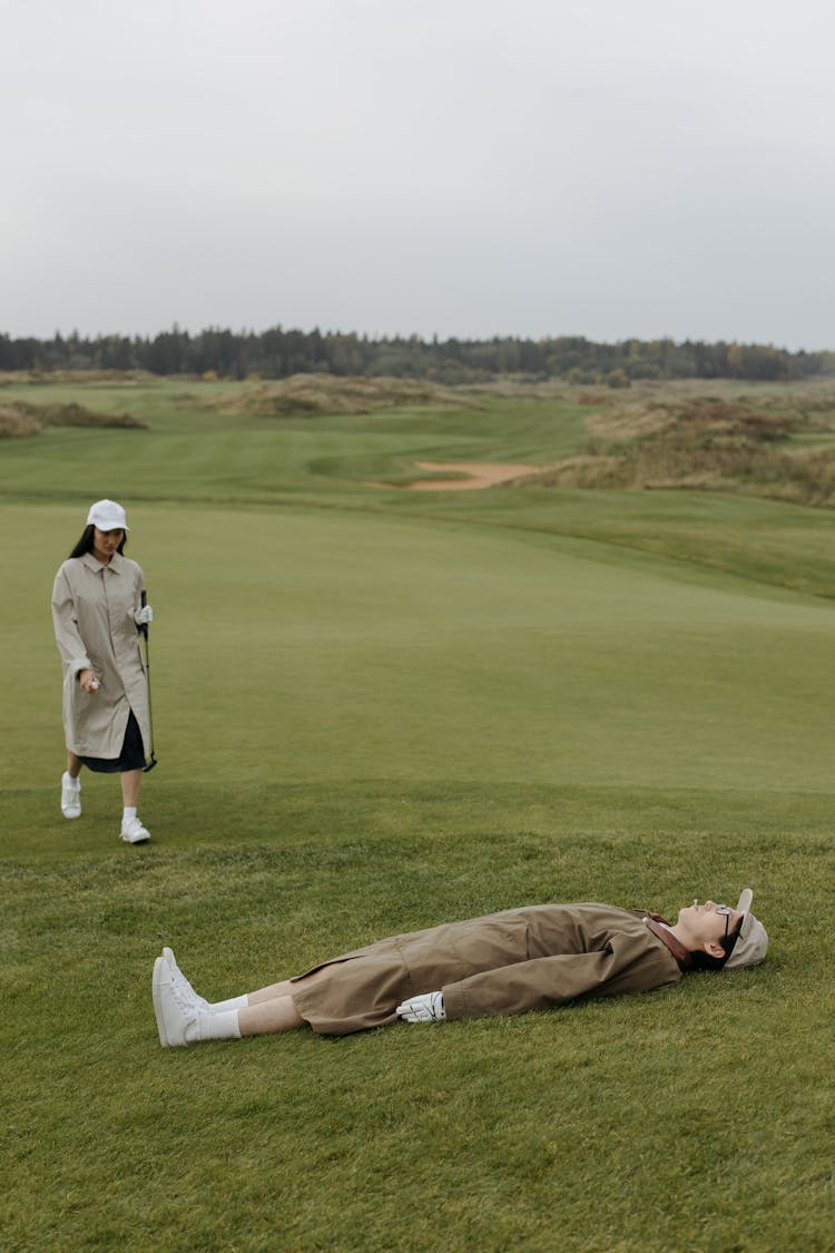 Man In Brown Coat Lying On The Field