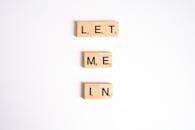 Close-Up Shot of Scrabble Tiles on a White Surface