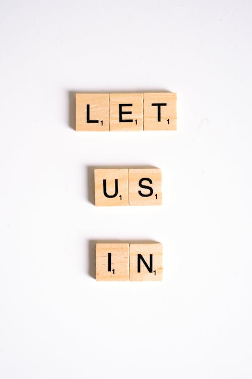 Close-Up Shot of Scrabble Tiles on a White Surface