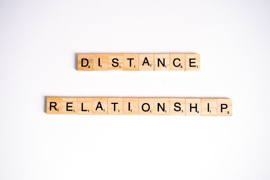 Conceptual image of Scrabble tiles spelling 'Distance Relationship' on a white background.