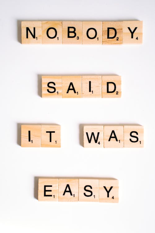 Close-Up Shot of Scrabble Tiles on a White Surface 