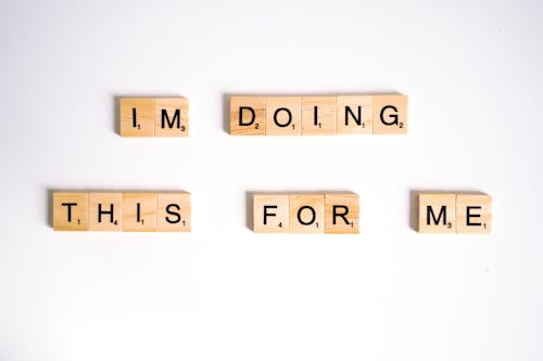 Close-Up Shot of Scrabble Tiles on a White Surface 