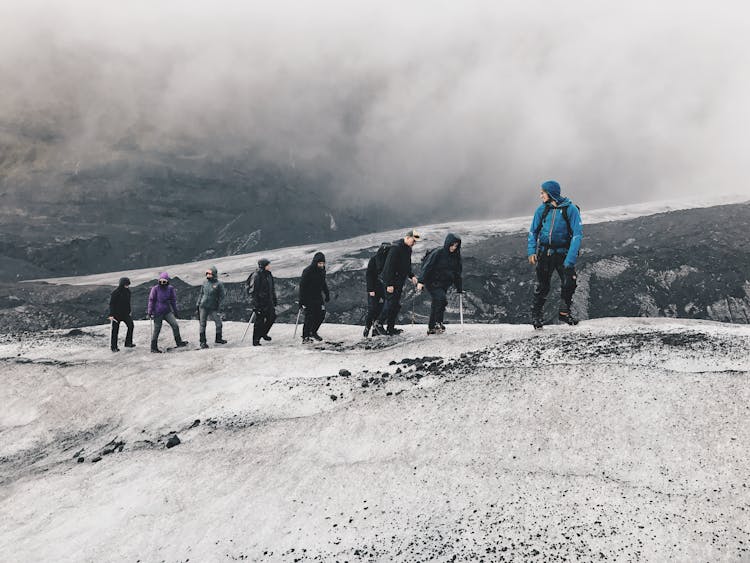 People Hiking The Snowy Mountains