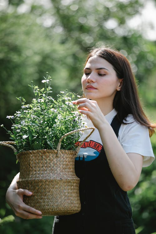 Kobieta W Białej Koszuli Trzyma Zieloną Roślinę