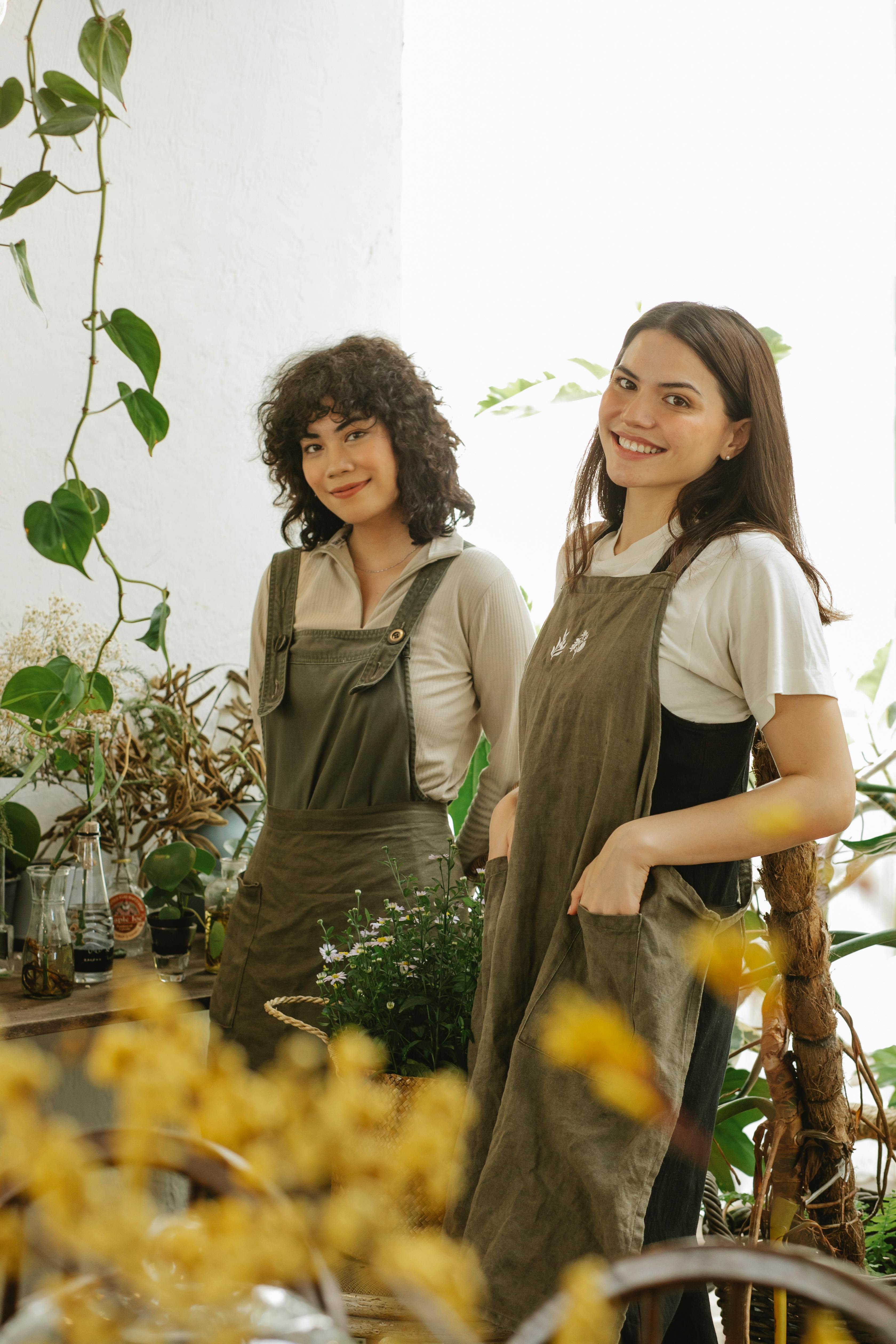positive florists in aprons looking at camera