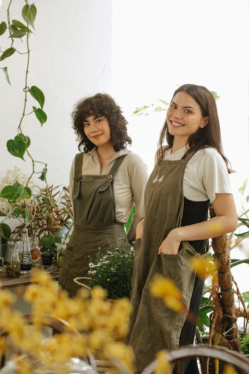 2 женщины, стоящие у зеленых растений