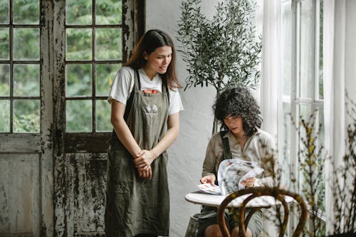 Focused customer with menu and waitress in cafe