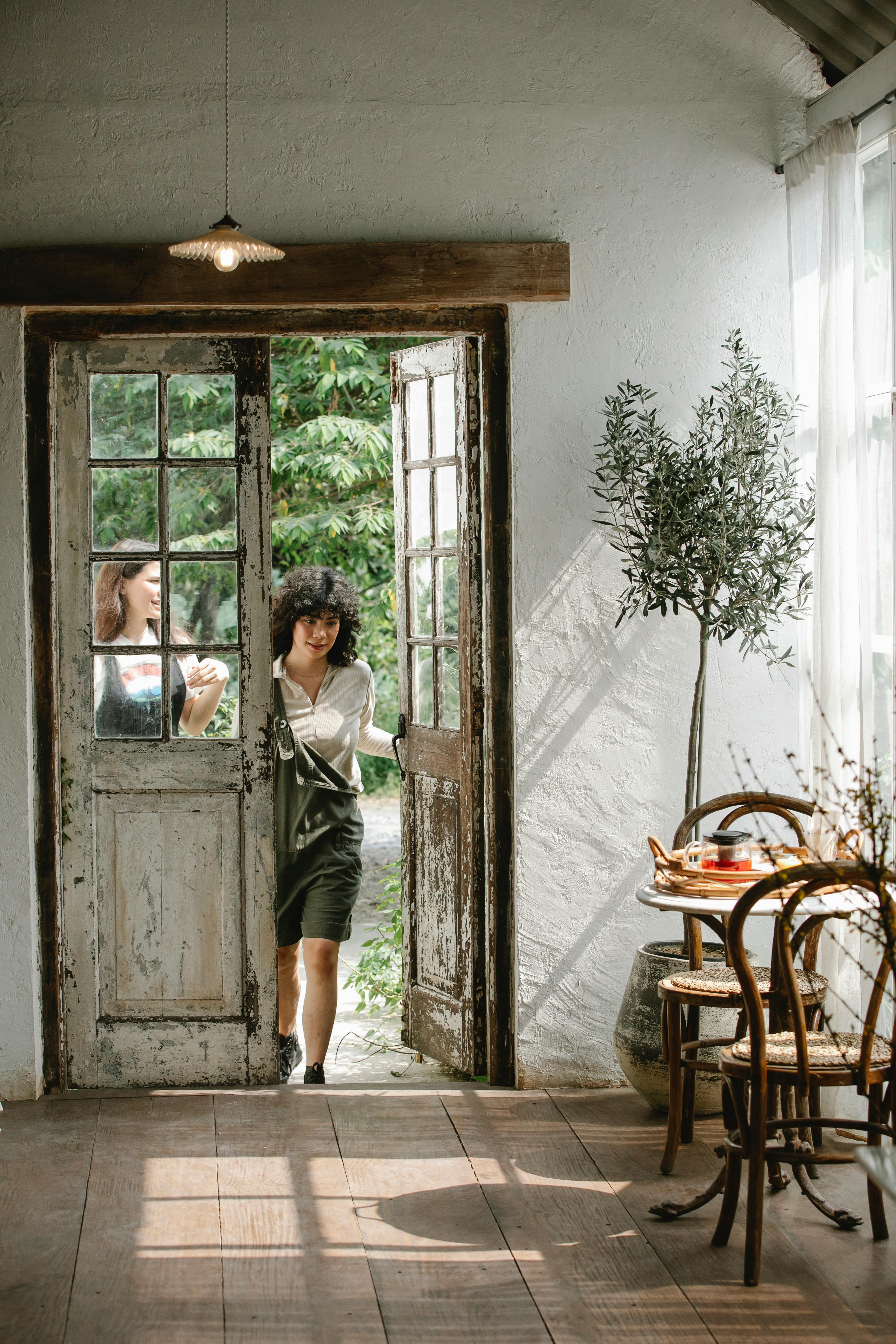 women coming in doorway of house