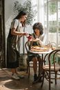 Woman pouring brewed tea into glass teacup to ethnic friend