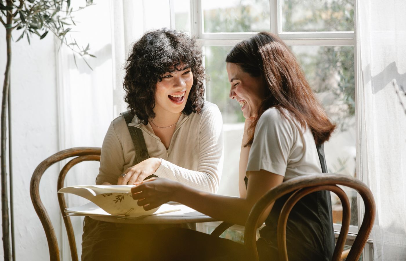 Joyful conversation between two women enjoying time together indoors.