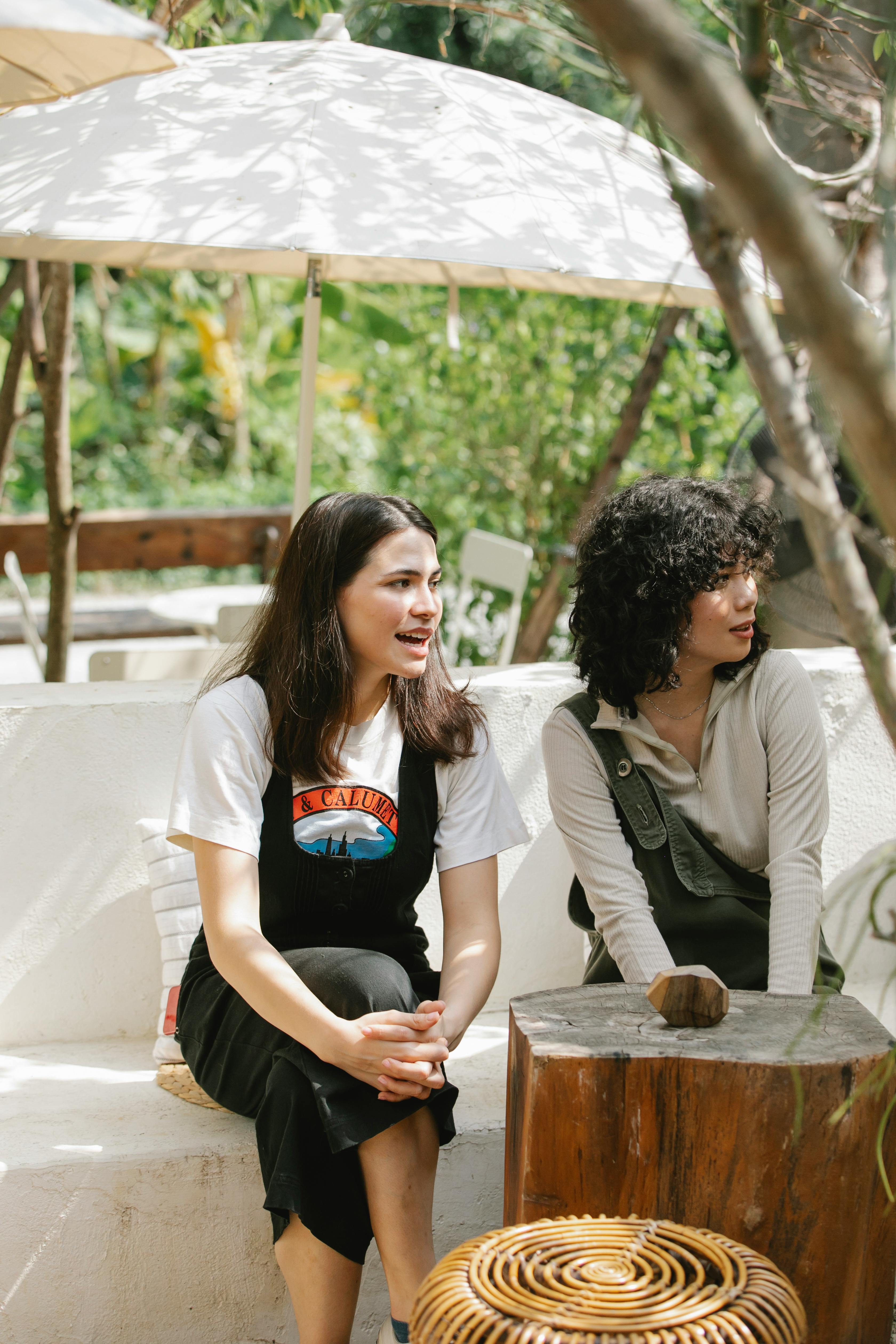 diverse female talking while sitting on terrace