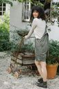 Smiling ethnic woman rolling cart in garden