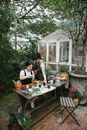 Female gardeners working in floral garden with potted plants