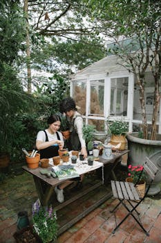 Female gardeners working in floral garden with potted plants with the Quote "The fewer rules a coach has, the fewer rules there are for players to break." written on it and have average color value #626355