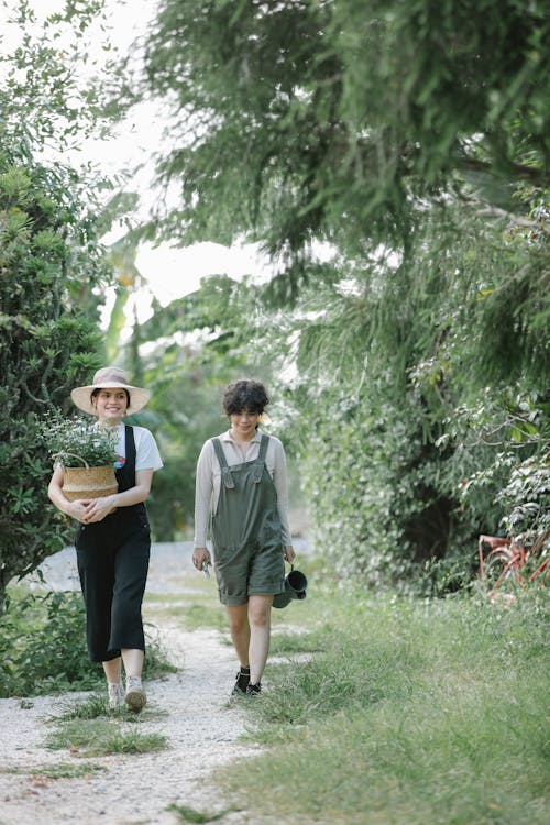 Positive women walking along footpath in countryside park