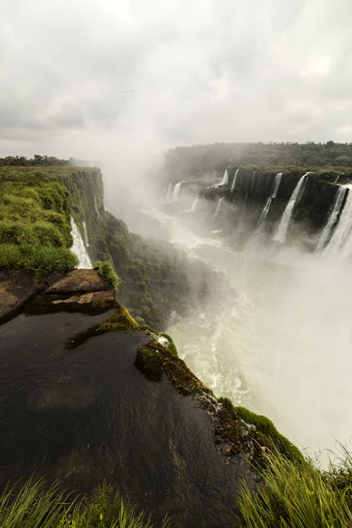 Amazing waterfall flowing through rocky cliffs on overcast day