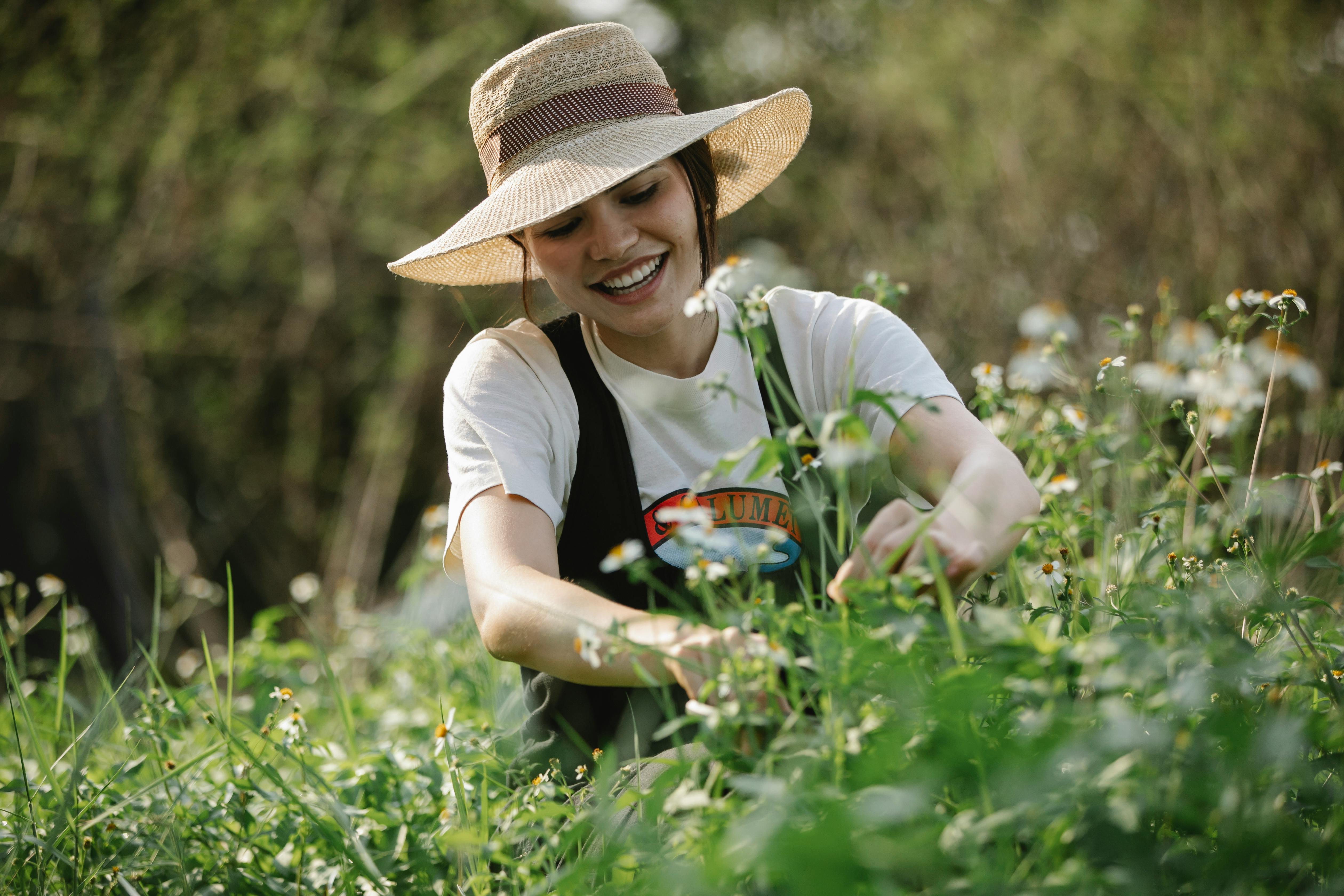 happy woman in hat near flowers