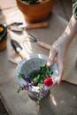 Woman taking flowers in vase for planting