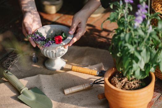 Gardener with ceramic vase of blooming branches