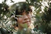 Dreamy ethnic gardener among olive branches in countryside
