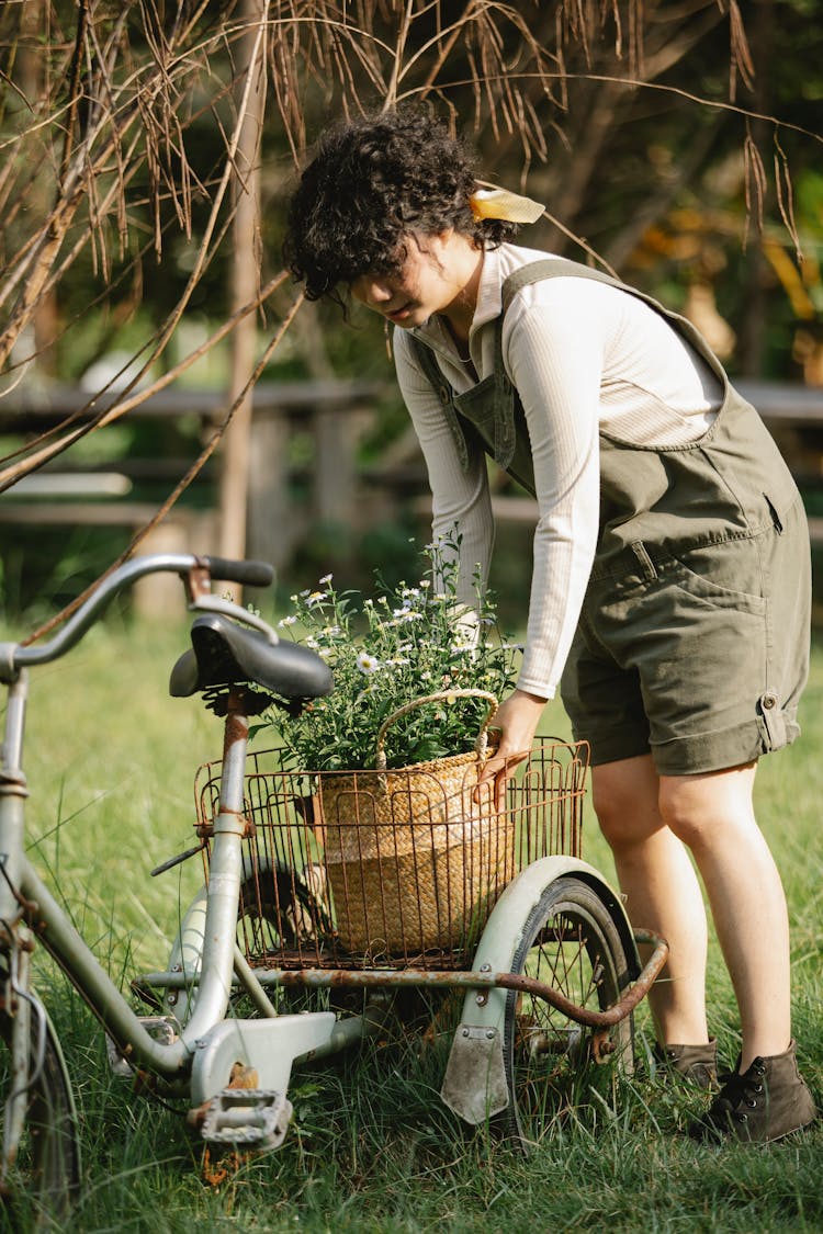 Serious Woman With Basket Of Flowers On Bicycle