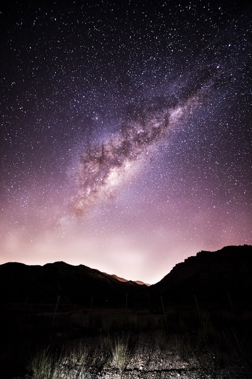 Amazing starry night sky over rocky terrain