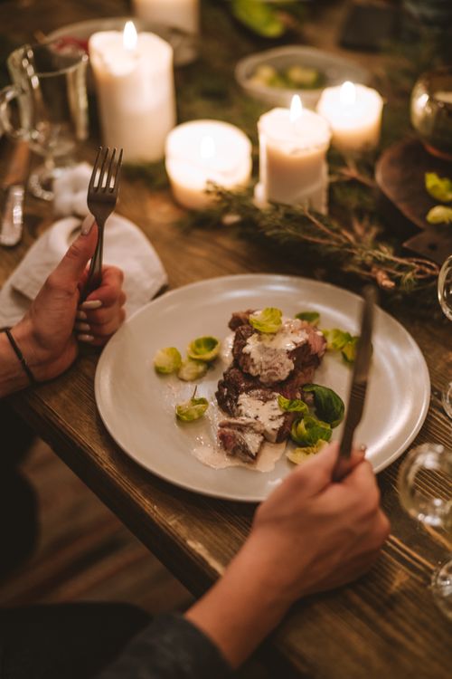 Free A cozy holiday dinner setting with candles and festive food in a warm ambiance. Stock Photo