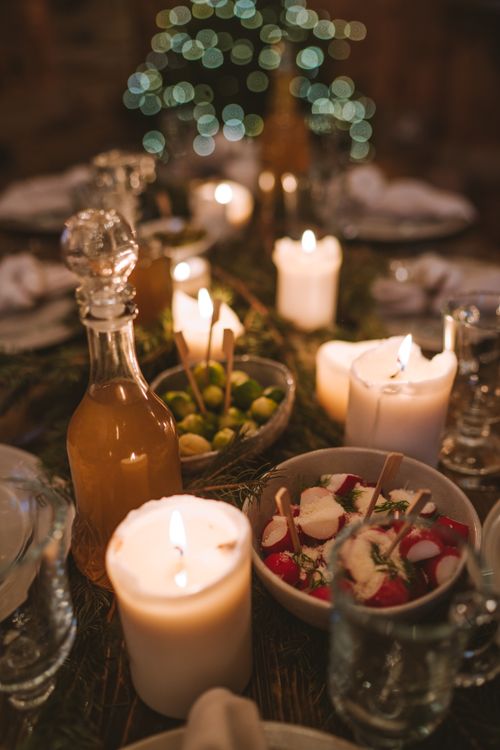 Free Warm and festive holiday dinner table with glowing candles and appetizers, creating a cozy atmosphere. Stock Photo